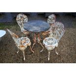 A Victorian-style weathered marble top cast iron terrace table and four chair set