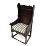 A 18th century oak winged armchair, with rope webbing seat