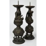 A pair of early 20th century Chinese bronze pricket candlesticks cast with dragons