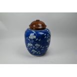 A 19th century Chinese blue and white prunus jar and hardwood cover, 26 cm high