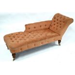 A Victorian scroll end chaise longue with faded pink buttoned upholstery