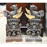 A pair of antique brass and cast iron armorial chenets
