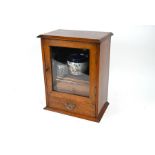 An Edwardian oak smokers cabinet c/w assorted contents