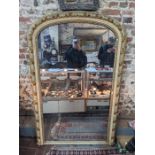 A large antique carved and gilded wood arched over mantel mirror