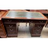 A reproduction mahogany pedestal desk with a green leather inset writing surface a central drawer