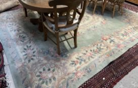 A large Chinese green ground rug together with two smaller Chinese rugs