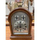 A 20th century oak cased bracket clock, with a domed top and carrying handle,
