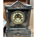 A black slate mantle clock of architectural form