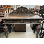 A 19th century oak side table with a fruit and scroll carved back above a rectangular top and two