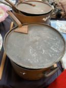 Assorted copper and cast iron saucepans with lids