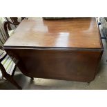 A Victorian mahogany gateleg dining table with a rectangular top and drop flaps on turned legs and