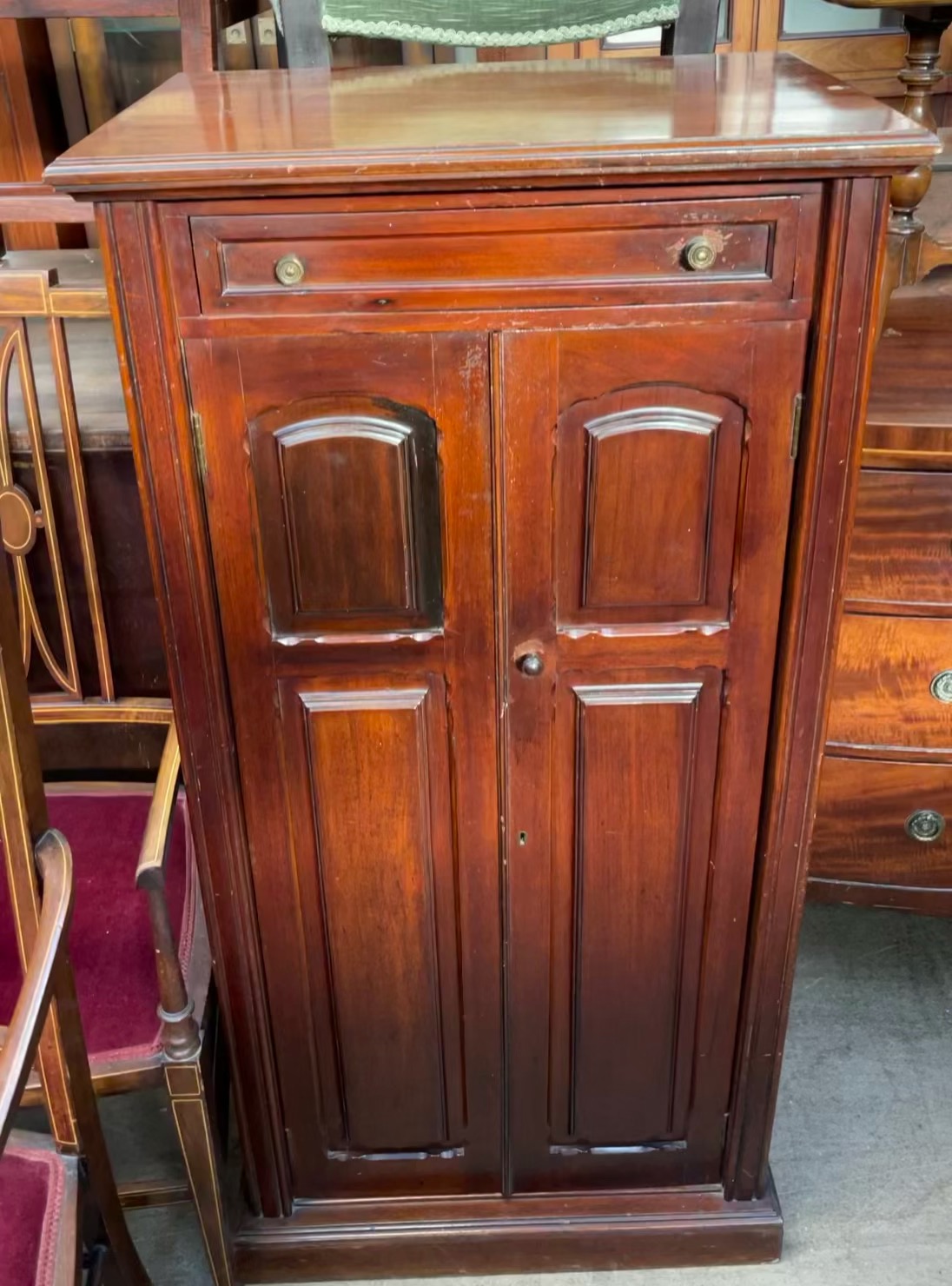 An Edwardian mahogany music cabinet with a rectangular moulded top above a rotating top drawer and