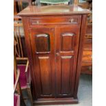 An Edwardian mahogany music cabinet with a rectangular moulded top above a rotating top drawer and