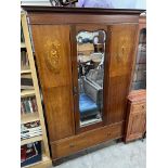 An Edwardian mahogany wardrobe with a central mirror and a base drawer on bracket feet together