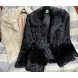 A black faux fur jacket together with another jacket