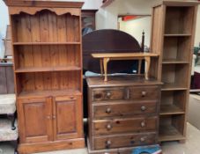A modern pine bookcase together with a stained pine chest of drawers,