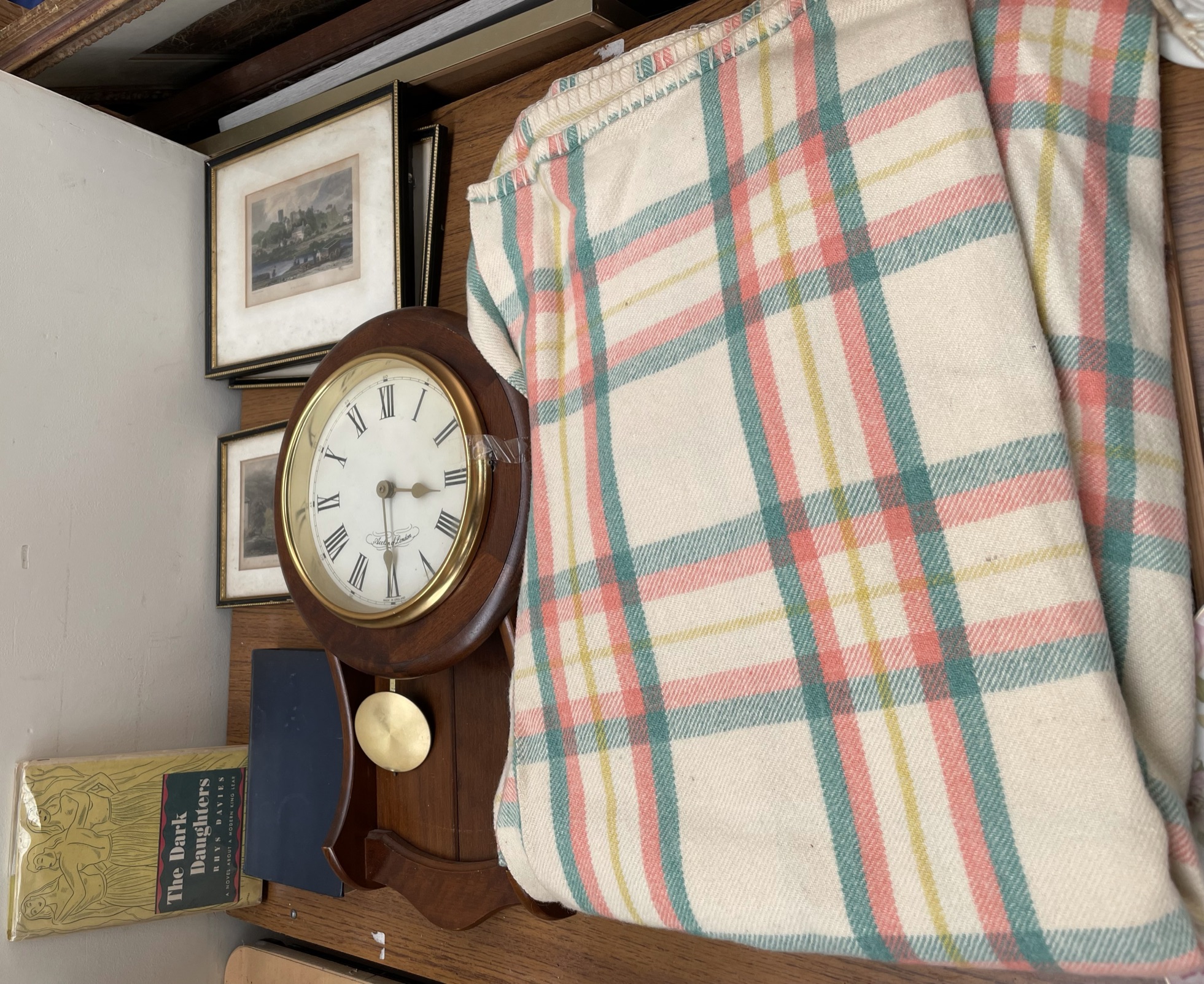 A wall clock together with a blanket, prints,