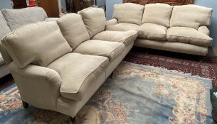 A pair of large cream upholstered three seater settees on turned legs with brass cappings and