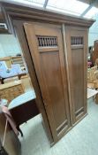 A mahogany wardrobe with a moulded cornice above two doors on a plinth base