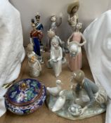 A collection of Lladro figures, including a girl on her knees feeding ducks, a matador,