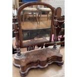 A Victorian walnut framed toilet mirror with an arched plate,