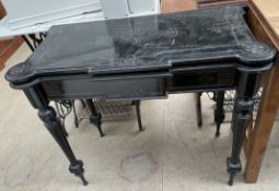 A late Victorian ebonised card table with a shaped fold over top on tapering legs
