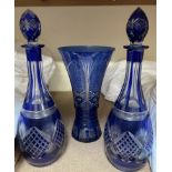 A pair of blue flash glass decanters together with a similar vase