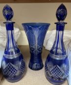 A pair of blue flash glass decanters together with a similar vase