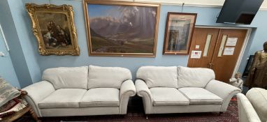 A pair of grey upholstered two seater settees on turned legs and casters