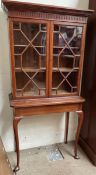 A 20th century oak bookcase with a moulded dentil cornice and a pair of Astragal glazed doors,