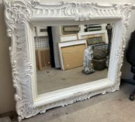 A large white painted wall mirror,