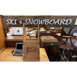 An Oakley sunglasses advertising display screen together with a ski and snowboard sign and a