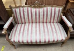 A French parcel gilt two seater settee on cabriole legs and peg feet