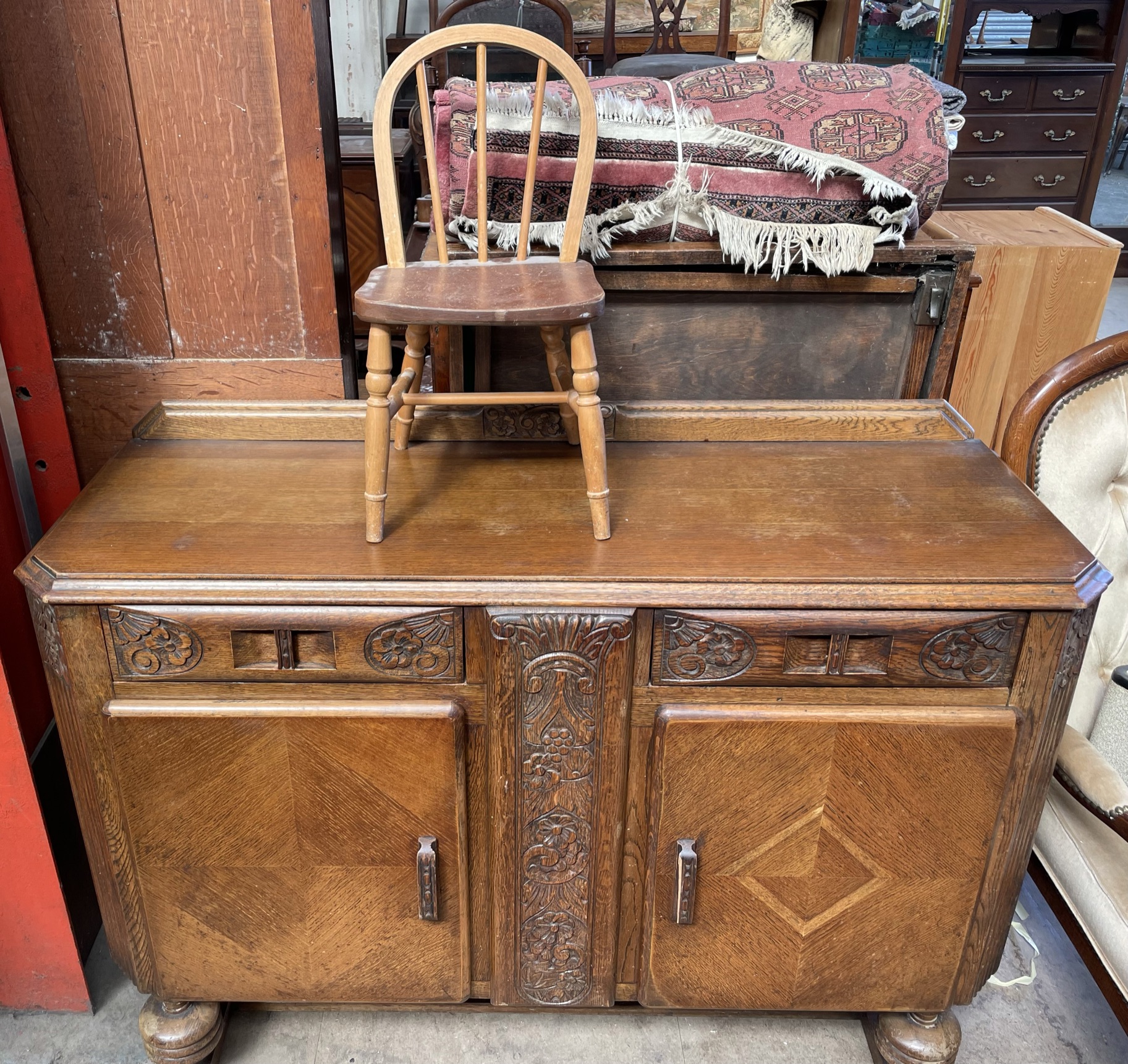 A 20th century oak sideboard with two drawers and two cupboards together with a child's chair and