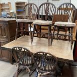 A 20th century oak drawleaf dining table with cup and cover legs together with a matched set of