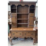 An oak dresser, the rack with a moulded cornice above shelves and cupboards,