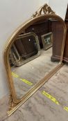 A gilt decorated overmantle mirror of arched form with a leaf scrolled top