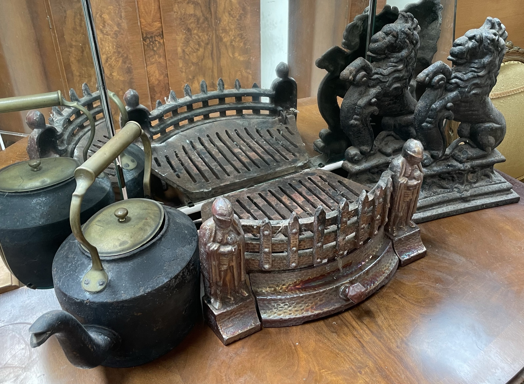 A pair of cast iron rampant lion door stops together with a fire grate and a kettle