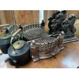 A pair of cast iron rampant lion door stops together with a fire grate and a kettle