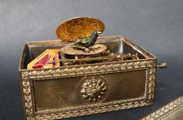 A gilt metal singing bird automaton music box, with a rectangular top decorated with leaves,