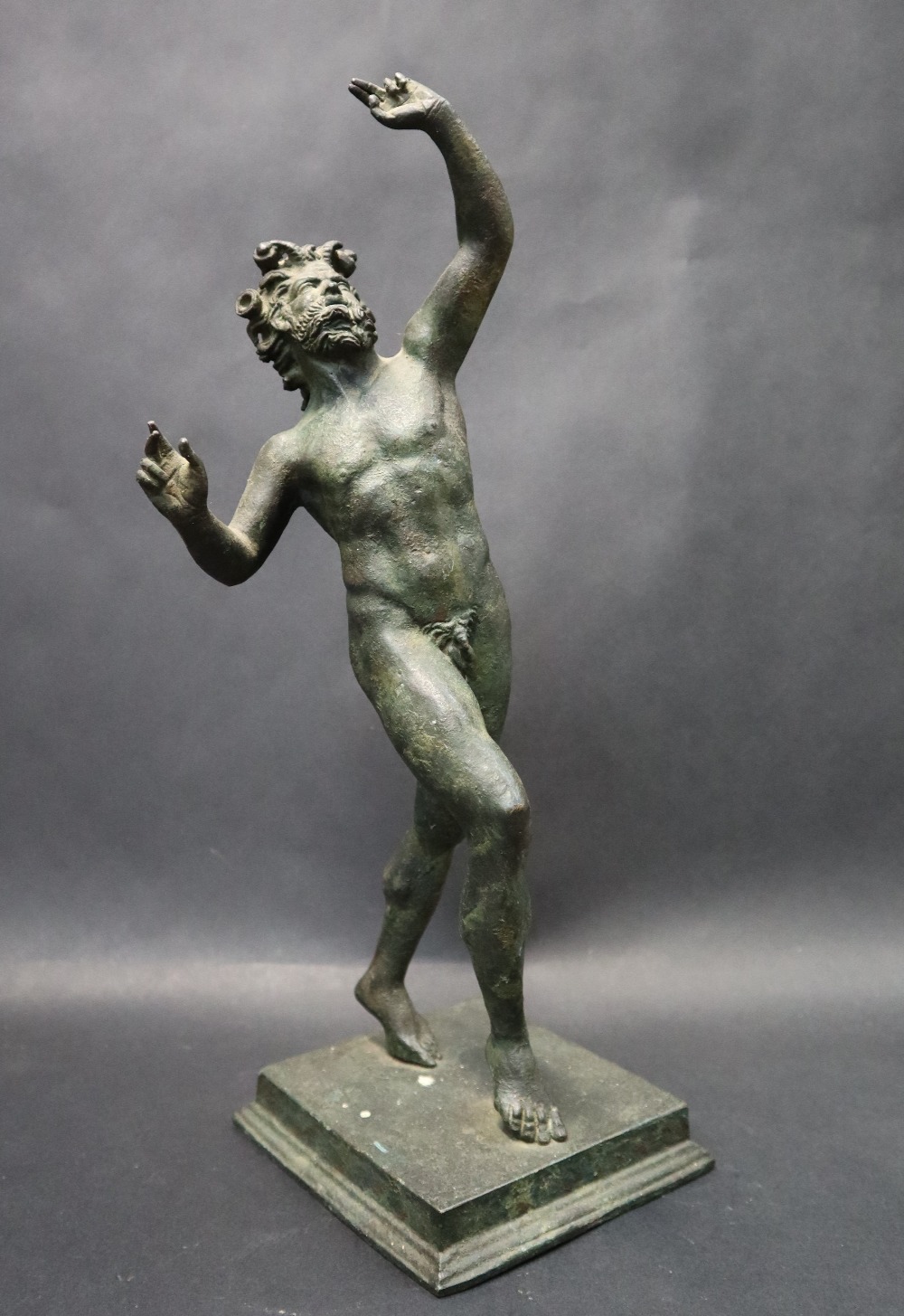 A bronze figurine of "The dancing Faun" on a stepped square base, after the antique, 31.