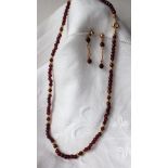 An 18ct gold and semi precious stone bead necklace (possibly garnets) together with matching