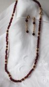 An 18ct gold and semi precious stone bead necklace (possibly garnets) together with matching