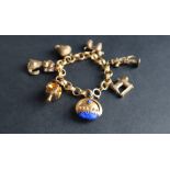A 9ct gold charm bracelet set with numerous charms including a sewing machine, a poodle, acorn,