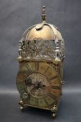 A Brass Lantern clock, the domed top housing a bell, with floral and leaf pierced panels,