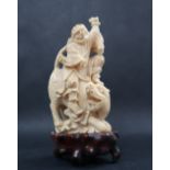 A simulated ivory figure group of a figure riding a tiger, 11cm high,