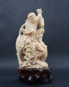 A simulated ivory figure group of a figure riding a tiger, 11cm high,