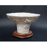 A Chinese blanc de chine or dehua porcelain libation cup, of rhinoceros horn form,