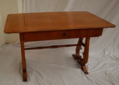 A Biedermeier style centre table with a shaped crossbanded top on lyre supports and spreading feet,