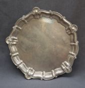 A silver salver, with a shell and scroll border on three tapering feet, Birmingham,